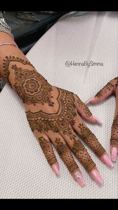 two hands with henna tattoos on them