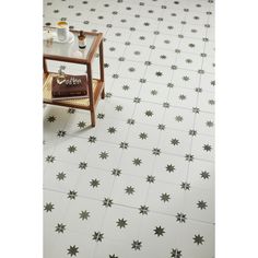 a white and black tiled floor with small stars on the tiles, next to a coffee table