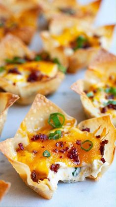 small appetizers with cheese, bacon and green garnishes on them