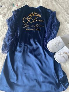 a blue dress and white slippers sitting on top of a bed