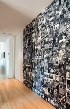 a wall covered in photos and pictures next to a hallway with wooden floors on both sides