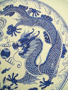 a blue and white plate with two dragon on it