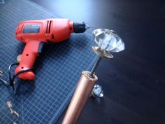 a drill, screwdriver and other tools on a table