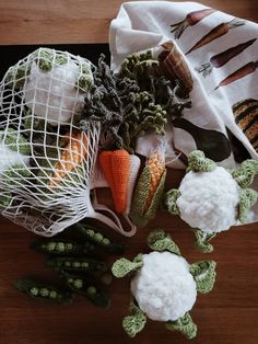 small stuffed animals sitting on top of a table next to carrots and other vegetables