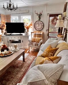 a living room filled with furniture and a flat screen tv sitting on top of a wooden table