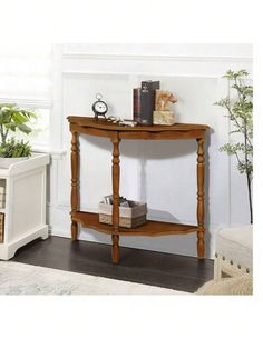 a small wooden table with a clock on top and some plants in the corner next to it