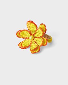 an orange and yellow flower brooch with pearls