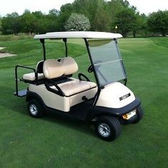 a golf cart parked in the grass near a hole