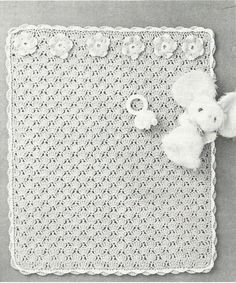 an old crocheted baby blanket with a teddy bear on it