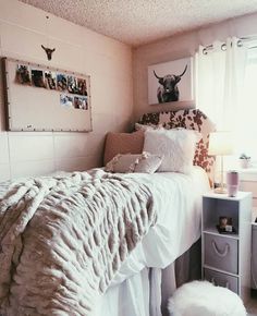 a white bed sitting next to a window in a room with pictures on the wall