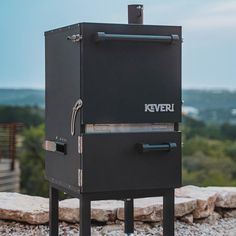 a black stove sitting on top of a rock covered ground