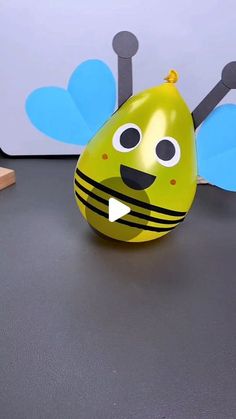 a yellow and black ball with a bee on it sitting next to a wooden block