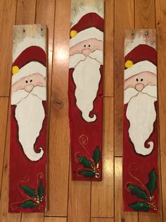 three painted santa clauss sitting on top of a wooden floor