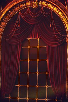 an open stage with red curtains and gold trim