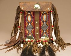 a brown leather purse with feathers and tassels