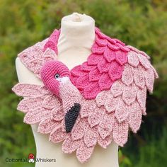 a crocheted pink and black flamingo scarf on a mannequin torso