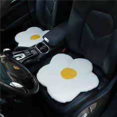 two fried eggs in the center of a car with steering wheel and dash stickers