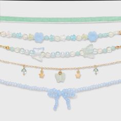 Accessorize your little one's outfit delightfully with the Girls' 5pk Blue Beaded Bow Choker Necklace Set from Cat & Jack™. Each choker measures 11 inches in length and features a secure lobster claw clasp for a secure and comfy fit. Made from durable polyester, acrylic and recycled iron, these necklaces are both stylish and sturdy, making them a great addition to your little fashionista's accessory collection. Cat & Jack™: Designed for all children so you can trust it's made for yours. Cute Preppy Beaded Necklaces, Tattoo Choker Necklace, Bow Choker, Tattoo Choker, Charm Choker Necklace, Bow Bracelet, Choker Necklace Set, Pearl Choker Necklace, Fancy Jewellery