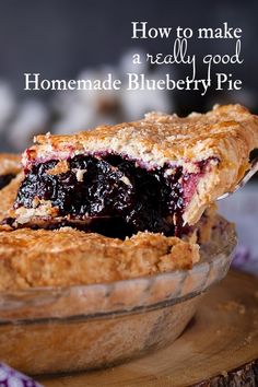 a pie with blueberries in it sitting on top of a wooden table