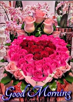 a heart shaped arrangement with pink roses in the center and good morning written on it