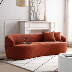 a living room with an orange couch and rug