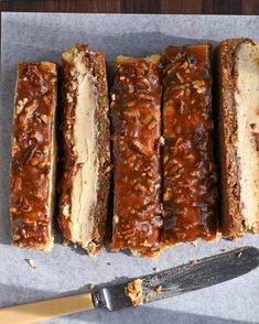 five slices of banana nut bread sitting on top of a piece of wax paper next to a knife