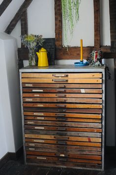 an old dresser with lots of drawers on it in a room that has exposed wood beams