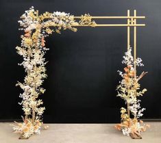 two gold and white floral arrangements are on display