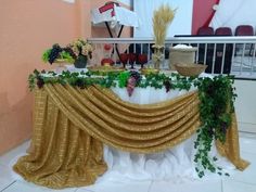 the table is covered with gold cloth and greenery