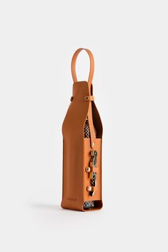 an orange leather bottle holder with buttons on the front and side, sitting on a white surface