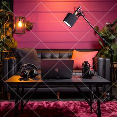 a laptop computer sitting on top of a table next to headphones and a lamp