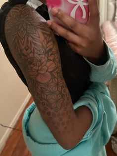 a woman with a tattoo on her arm taking a selfie