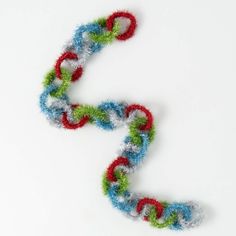 an odd shaped object made out of yarn on a white surface with the letter s in it's center