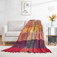 a living room with a white couch and colorful blanket