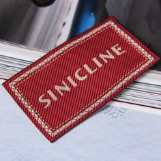 a red name tag sitting on top of a pile of papers