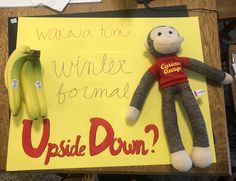 a stuffed monkey is next to a sign that says upside down with bananas on it