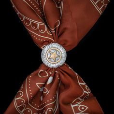 A standout Western classic. This hand-engraved scarf slide is constructed of solid sterling silver, accented with a 14k gold fill three-dimensional star and serpentine engraved disc. Wear your wild rag with style. Measures 1 1/2" by 1 1/2" All Vogt sterling items come with the Vogt Family Unconditional Lifetime Guarantee. If for any reason your Vogt piece bends, breaks, or cracks it will be repaired or replaced free of charge. No questions asked.