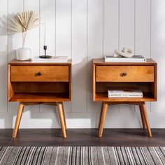 two wooden nightstands side by side against a white wall with a striped rug on the floor