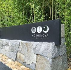 there is a sign that says hoshinya on the side of a stone wall