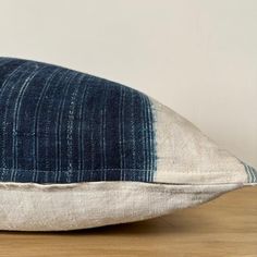 a blue and white pillow sitting on top of a wooden table