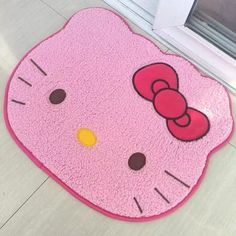 a pink hello kitty door mat on the floor