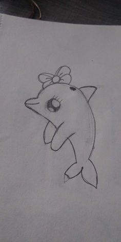 a drawing of a dolphin with a bow on its head and eyes drawn in pencil