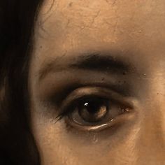 a close up of a woman's face with tears on her eyes