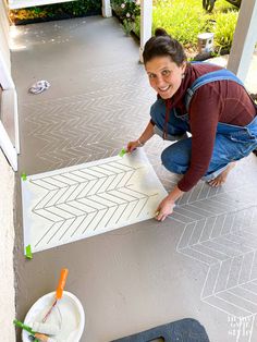 a woman kneeling down on the ground with a piece of paper in front of her