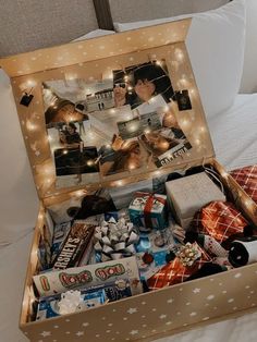 an open box filled with various items on top of a bed