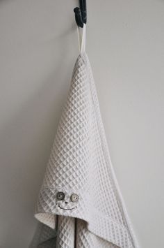 a white towel hanging from a hook on a wall