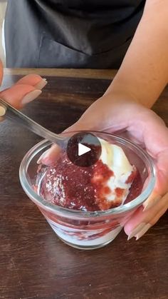 a person holding a spoon over a bowl of ice cream