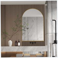 a bathroom with marble counter tops and gold trim around the mirror, along with a vase filled with flowers