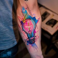 a man's arm with a colorful light bulb tattoo on it