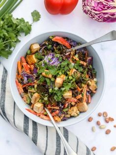 a bowl filled with salad next to some vegetables